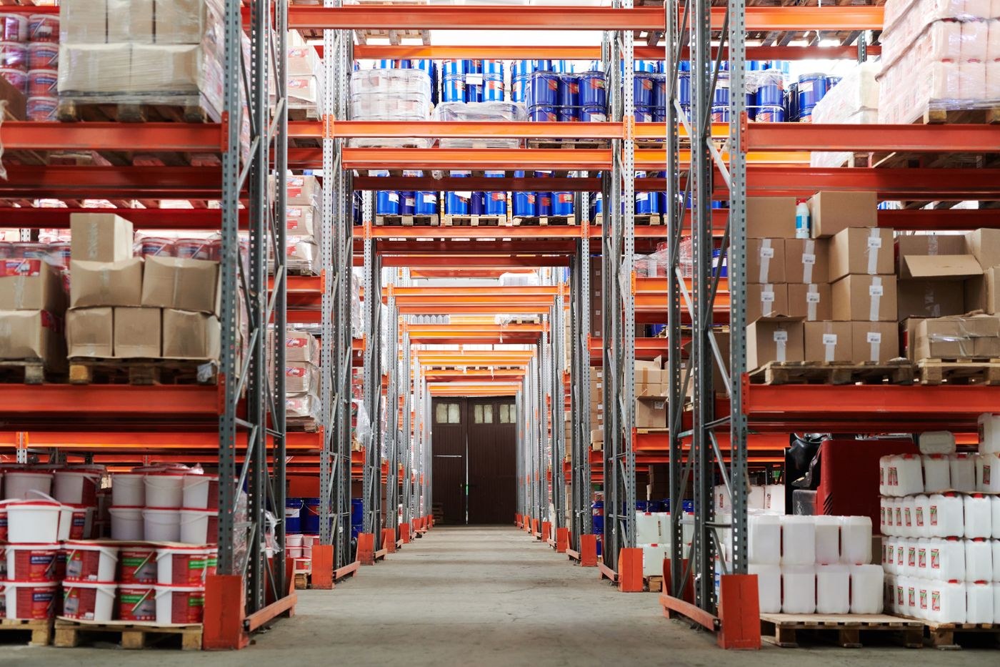 Warehouse aisle lined with stocked pallet racks